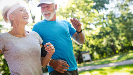 Beautiful mature couple jogging in nature living healthy